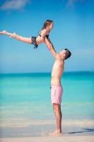 familie van vader en sportief weinig meisje hebben pret Aan de strand foto