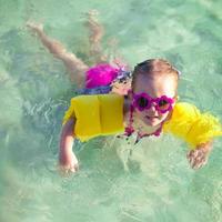 weinig schattig meisje met duiken in de zee in mooi hoor zonnebril foto