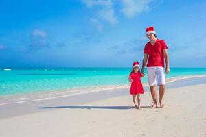 familie in Kerstmis hoed Bij tropisch strand foto