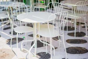 wit tafels met stoelen Bij zomer leeg Open lucht cafe in Griekenland foto