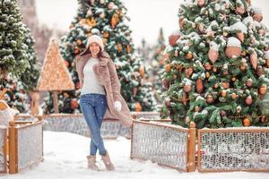 gelukkig meisje in de buurt dennenboom Afdeling in sneeuw voor nieuw jaar. foto