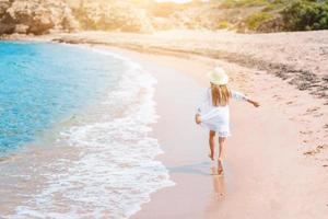 schattig weinig meisje Bij strand gedurende caraïben vakantie foto