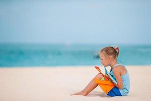 schattig klein meisje veel plezier op tropisch strand tijdens vakantie foto