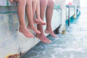 detailopname hangende hun poten in de water Aan houten pier foto