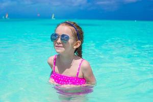 aanbiddelijk weinig meisje in de zee Aan tropisch strand vakantie foto