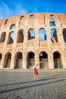 aanbiddelijk weinig actief meisje hebben pret in voorkant van colosseum in Rome, Italië. schattig sportief kind maken wiel achtergrond van beroemd aantrekkelijk in Europa. foto