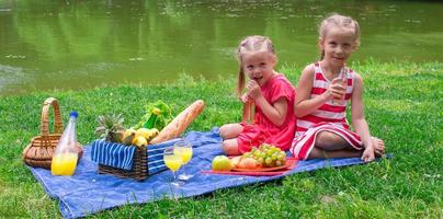 schattig weinig meisjes picknicken buitenshuis foto