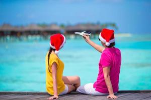 paar in de kerstman hoeden Aan een tropisch strand Bij Maldiven foto