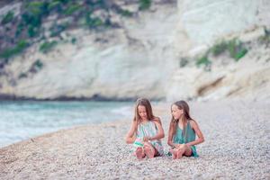 weinig meisjes hebben pret Bij tropisch strand gedurende zomer vakantie foto