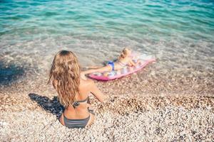 jong vrouw genieten van de zon zonnen door perfect turkoois oceaan foto