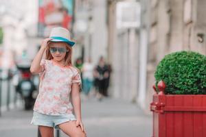 aanbiddelijk mode weinig meisje buitenshuis in Europese stad foto