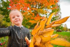 weinig meisje nemen selfie portret met geel en oranje bladeren boeket in fa foto