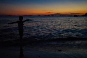 silhouet van weinig meisje Bij zonsondergang Aan de eiland boracay, Filippijnen foto