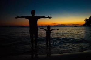 vader en dochter silhouetten in zonsondergang Bij de strand Aan boracay, Filippijnen foto