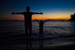 vader en dochter silhouetten in zonsondergang Bij de strand Aan boracay, Filippijnen foto