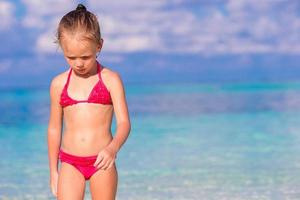 schattig klein meisje op het strand tijdens de zomervakantie foto