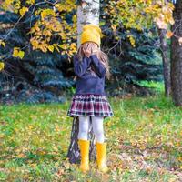 weinig meisje spelen verbergen en zoeken in herfst Woud foto