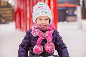 schattig klein gelukkig meisje schaatsen op de ijsbaan foto