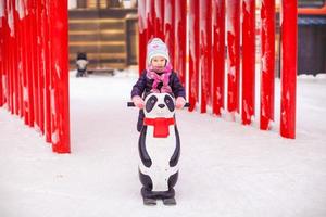 weinig gelukkig meisje het schaatsen Aan de ijsbaan foto