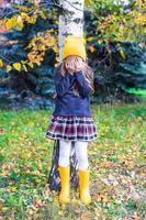 weinig meisje spelen verbergen en zoeken in herfst Woud foto