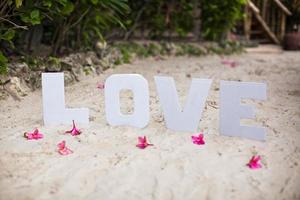 woord liefde Aan zanderig strand Bij mooi toevlucht foto