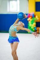 mooi weinig actief gymnast meisje met haar prestatie Aan de tapijt foto