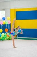 mooi weinig actief gymnast meisje met haar prestatie Aan de tapijt foto