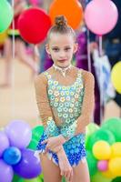 mooi weinig actief gymnast meisje met haar prestatie Aan de tapijt foto