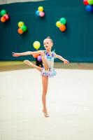 mooi weinig actief gymnast meisje met haar prestatie Aan de tapijt foto