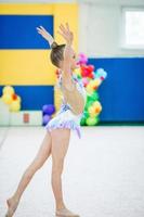 mooi weinig actief gymnast meisje met haar prestatie Aan de tapijt foto