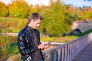 jong Mens met een telefoon in de park foto