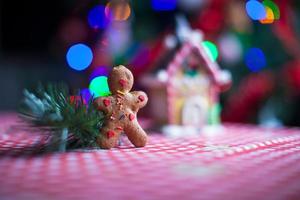 peperkoek Mens in voorkant van zijn snoep gember huis achtergrond de Kerstmis boom lichten foto