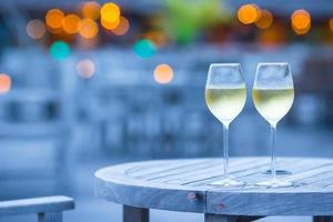 twee glazen smakelijke witte wijn bij zonsondergang foto
