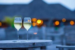 twee glazen smakelijke witte wijn bij zonsondergang foto