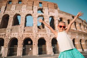 weinig meisje in voorkant van colosseum in Rome, Italië foto