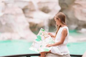 jong mooi meisje in de buurt fontein fontana di Trevi met stad kaart foto