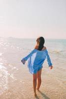 vrouw houdende Aan de strand genieten van zomer vakantie op zoek Bij de zee foto