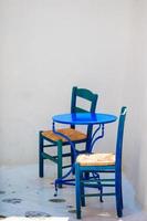 blauw stoel en tafel Aan straat van typisch Grieks traditioneel dorp Aan Mykonos eiland, Griekenland, Europa foto