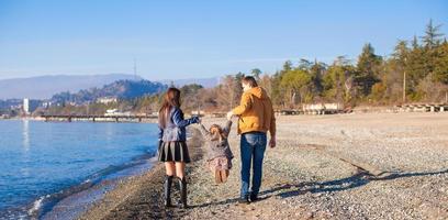 familie van drie hebben pret in de buurt de zwart zee in winter zonnig dag foto