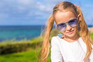 portret van aanbiddelijk weinig meisje buitenshuis gedurende zomer vakantie foto