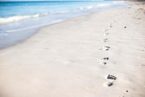 menselijk voetafdrukken Aan wit zand van de caraïben eiland foto