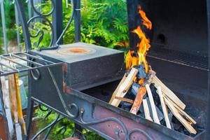 detailopname schot van Open camping brand voor barbecue foto