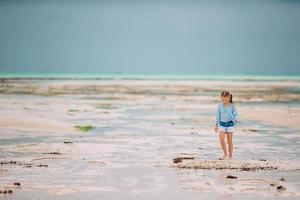 schattig klein meisje op het strand tijdens de zomervakantie foto