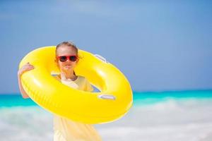 gelukkig kind met opblaasbaar rubber cirkel hebben pret Aan de strand foto