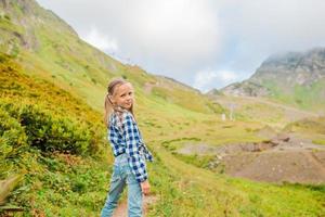 mooi gelukkig weinig meisje in bergen in de achtergrond van mist foto
