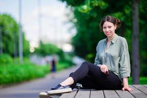 gelukkig jong stedelijk vrouw in park. Kaukasisch toerist genieten warm zomer dag buitenshuis. foto