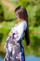 zwanger vrouw in buitenshuis park, warm weer foto