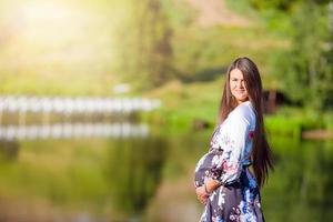 zwanger vrouw in buitenshuis park, warm weer foto