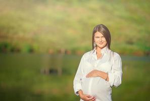 zwanger vrouw in buitenshuis park, warm weer foto