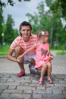 jong gelukkig vader met schattig dochter in de park hebben pret foto